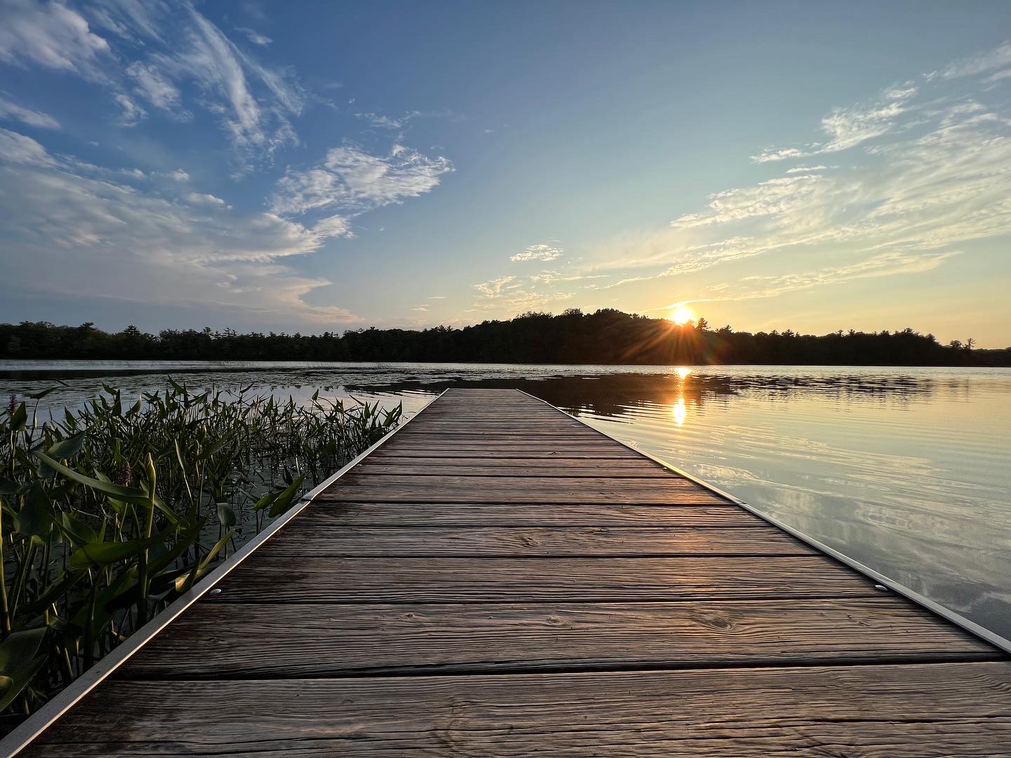 Picture of a dock with a sunset over the lake